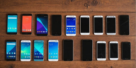 Various used Android phones on a wooden table