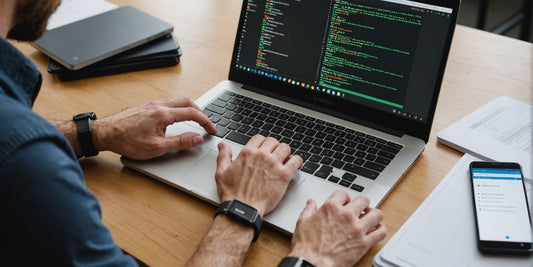 Developer working on Android Studio with a smartphone